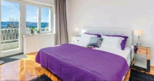 a bedroom with a purple bed and a balcony at Villa deluxe "H" - private jacuzzi in Novi Vinodolski