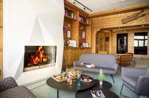 a living room with a fireplace and a couch at Hôtel Club mmv Plagne 2000 in Aime-La Plagne