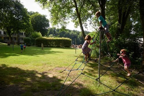 two children playing on a playground in a park at Seehotel Grunewald in Berlin