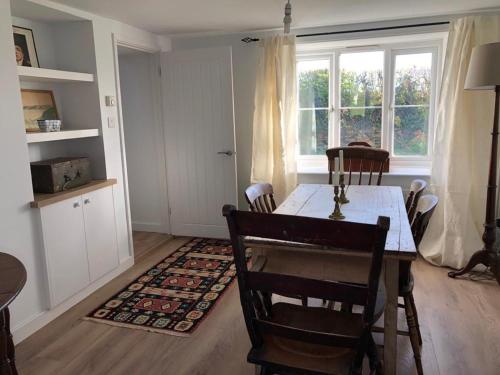 a dining room with a table and chairs and a window at Hollybush cottage in Abergavenny