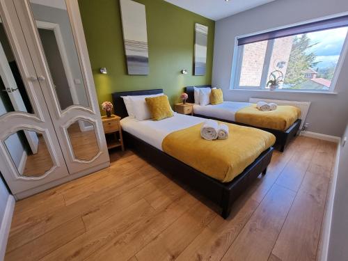 een slaapkamer met 2 bedden en een raam bij 144 - ExcellentStays - 2 Bedroom Flat in Stanwell