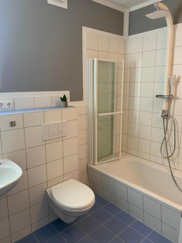 a bathroom with a toilet and a tub and a sink at Annalena in Schwerin