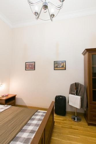 a bedroom with a bed and a suitcase on a chair at Friends Hostel & Apartments in Budapest