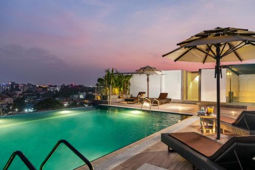 a swimming pool with a view of a city at night at Vivanta Thiruvananthapuram in Trivandrum