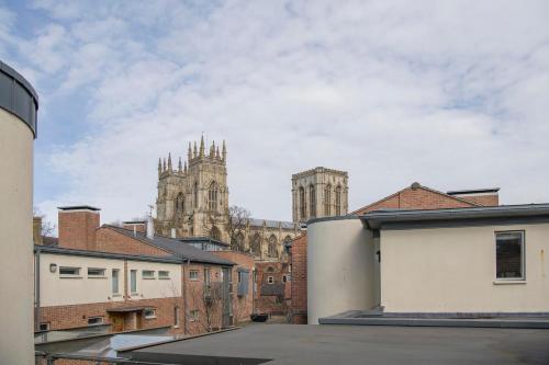 uma vista para uma catedral a partir dos telhados dos edifícios em St Helen's House with Minster views em York