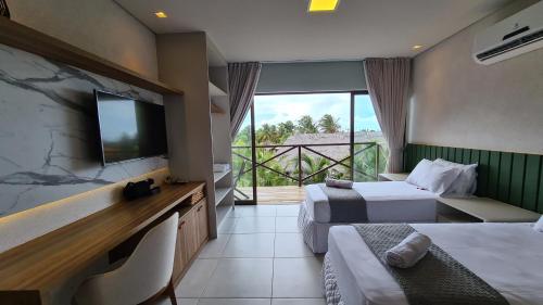 a hotel room with two beds and a flat screen tv at Belíssimo apartamento em Barra Grande Cobertura Villas BobZ 101 m2 com Vista Para o Mar, Barrinha, Barra Grande-PI in Barrinha