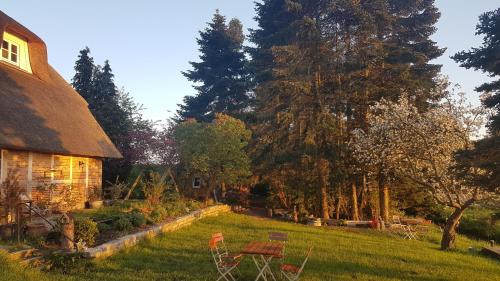 a yard with a house and a table and chairs at Haus Anna Elbe, Bauernhaus-Ferienwohnungen an der Elbe in Hamburg