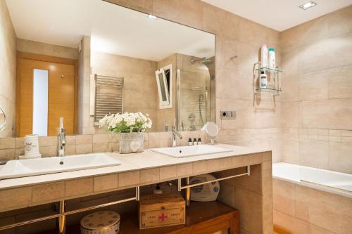 y baño con 2 lavabos, espejo y bañera. en Stay U-nique Apartments Sardenya, en Barcelona