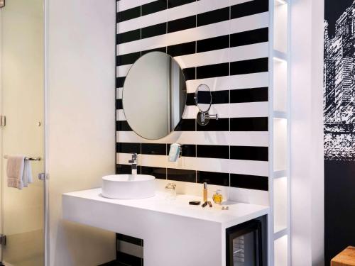 a bathroom with a white sink and a mirror at ibis Styles Dubai Airport Hotel in Dubai