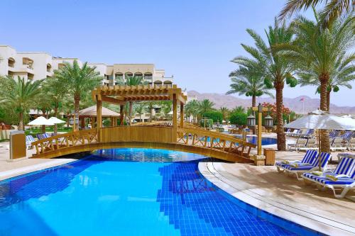 a bridge over a swimming pool at a resort at InterContinental Aqaba by IHG in Aqaba