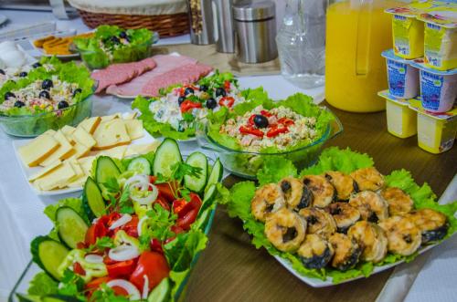a table topped with plates of food and salads at Hotel Voyager in Tbilisi City
