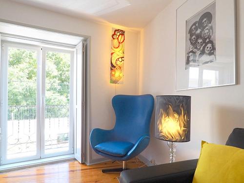 a living room with a blue chair and a window at Bela Vista - Lissabon Altstadt in Lisbon