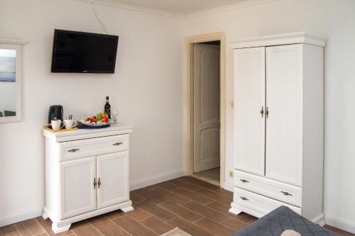 a room with white cabinets and a tv on the wall at Szépasszony Fogadó in Eger
