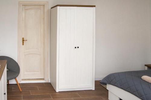 a bedroom with a white door next to a bed at Szépasszony Fogadó in Eger