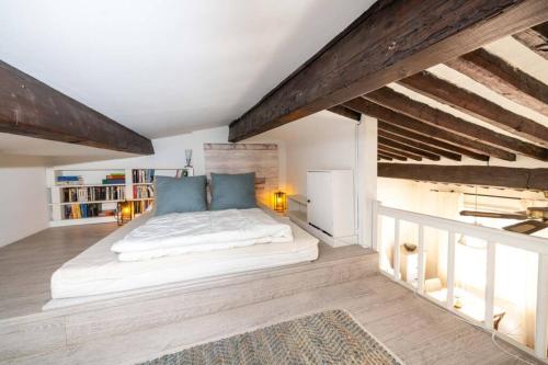 a bedroom with a large white bed with blue pillows at LE RAVISSANT - 50m du Port - très calme in Cassis
