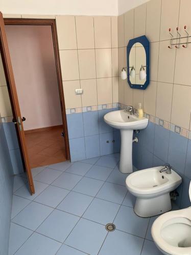 a bathroom with a sink and a toilet and a mirror at Marconi Apartments in Durrës