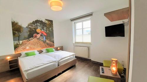 a bedroom with a bed and a painting on the wall at Winkelwerkstatt Hotel in Kröv