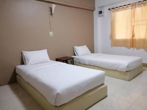 a room with two beds and a window at Phuviewplace Hotel - โรงแรมภูวิวเพลส in Ban Ngun