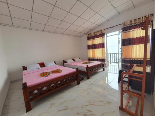 a room with two beds and a balcony at Sa Rest Inn in Haputale