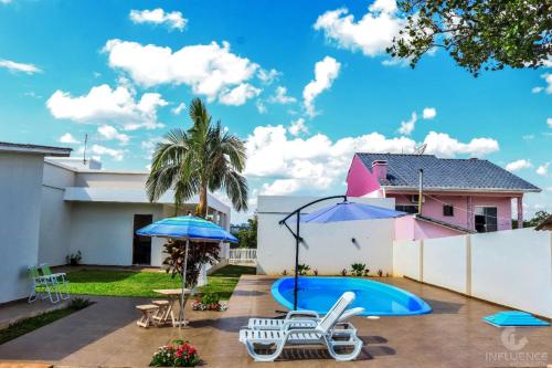 a backyard with a swimming pool and a house at Pousada São Gabriel in Ametista do Sul