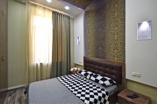 a bedroom with a checkered bed and a window at Amiryan street, 1 bedroom New Renovated, Modern apartment AM777 in Yerevan