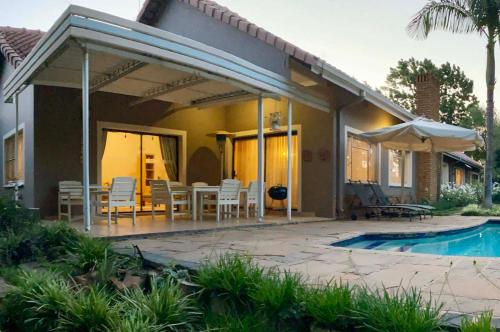 a house with a patio and a swimming pool at Royal Ridge Guesthouse in Pretoria