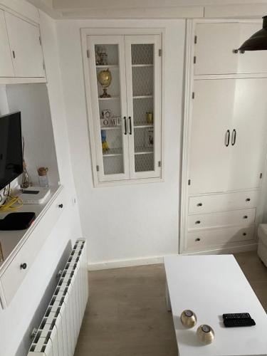 eine Küche mit weißen Schränken und einem weißen Tisch in der Unterkunft Casa Romántica "La CHELA" in Vejer de la Frontera