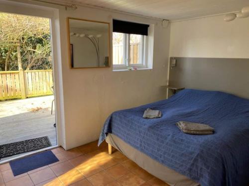 a bedroom with a bed and a door to a deck at Mysigt gästhus med cykelavstånd till havet! in Skivarp