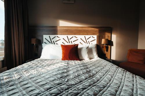 a bedroom with a large bed with orange and white pillows at Hotell Östersund in Östersund