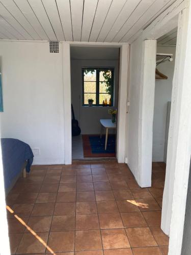 a hallway of a house with a tile floor at Mysigt gästhus med cykelavstånd till havet! in Skivarp