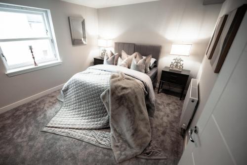 a bedroom with a bed with a blanket on it at The Old Fire Station in Kelso