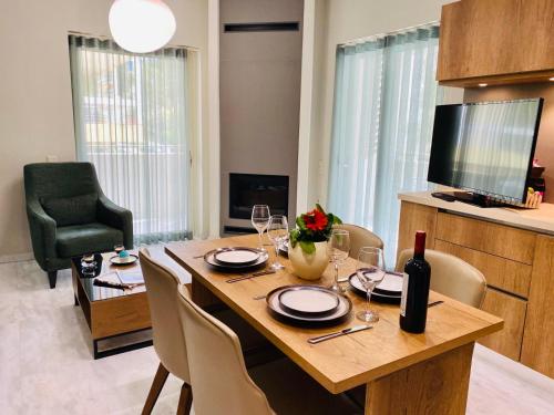 a dining room with a table and chairs and a television at Olygreen Athens Residences in Athens