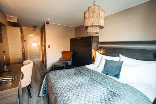 a bedroom with a bed and a desk and a chair at Hotell Östersund in Östersund