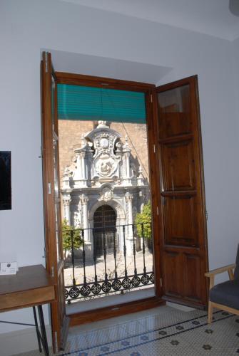 an open door to a building with a balcony at La Perla Granada Suites in Granada
