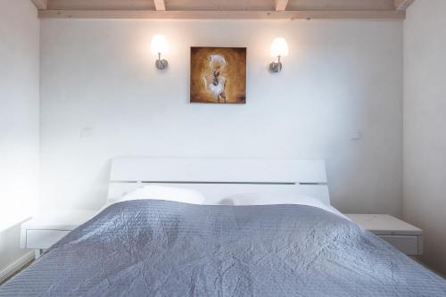 a bedroom with a bed with a painting on the wall at Ferienhaus Süderoog in Dagebüll