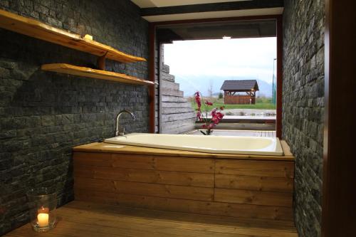eine Badewanne in einem Raum mit Fenster in der Unterkunft Apartmany Sileas in Veľká Lomnica