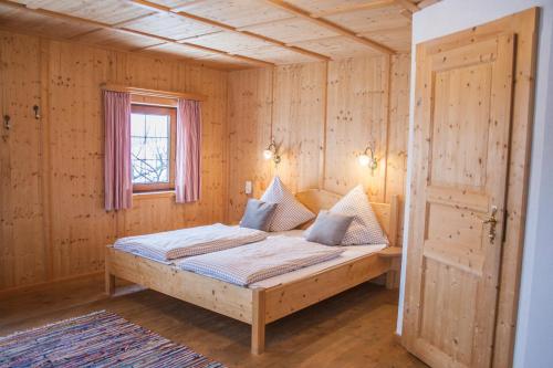 sypialnia z łóżkiem w drewnianym pokoju w obiekcie Ferienhaus Tuxerhof w mieście Achenkirch