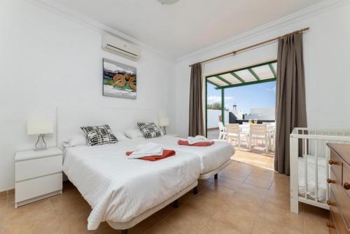 een slaapkamer met 2 bedden en een balkon bij Villa Costa Papagayo 6 in Playa Blanca