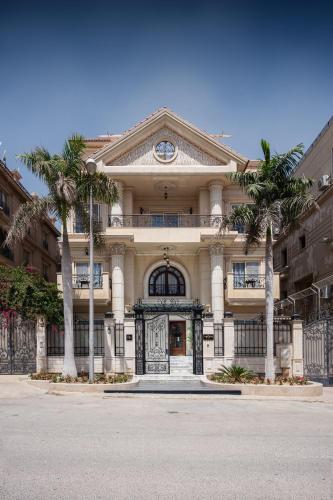a large building with palm trees in front of it at Maran Residence in Cairo