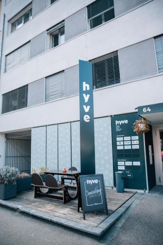 a table and chairs in front of a building at Hostel by Hyve Basel in Basel