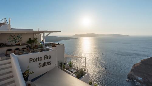a sign on the side of a building overlooking the ocean at Porto Fira Suites in Fira