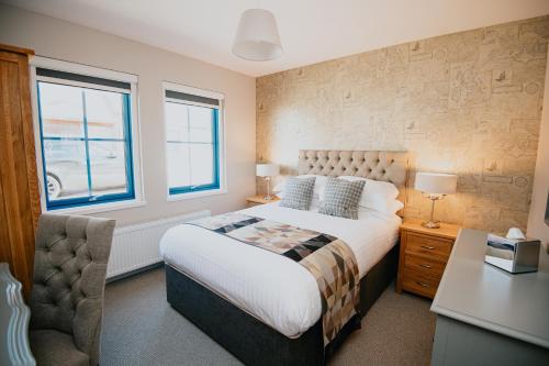 a bedroom with a bed and a desk and window at The Seafield Arms Hotel Cullen - Self Catering in Cullen