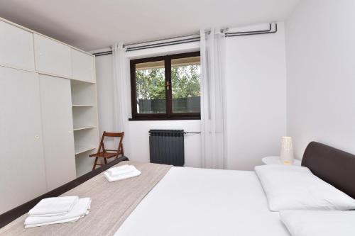 um quarto branco com uma cama e uma janela em Apartment Ivan em Primošten