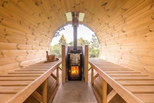 una habitación con estufa de leña en una cabaña de madera en ENJOY Cozy Romance Hills Forest Gardens Views Sauna Whirlpool Bath en Jablonné v Podještědí