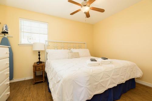 - une chambre avec un lit blanc et un ventilateur de plafond dans l'établissement Unobstructed Oceanfront SEA TURTLE Unit 2 Beach Pad!, à Surfside Beach