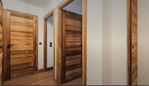 a hallway with wooden doors and a mirror at Interlude Megeve in Megève