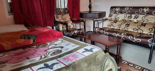 a room with two beds and a table and a bed sidx sidx sidx at IMPERIAL COTTAGE, HILL BUNK OOTY in Ooty