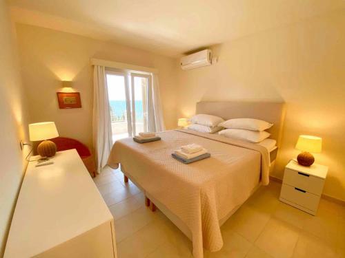 una camera da letto con un letto grande e una finestra di Paleopetres K-Eight - Premium Suite - Kalami - a Kalámi