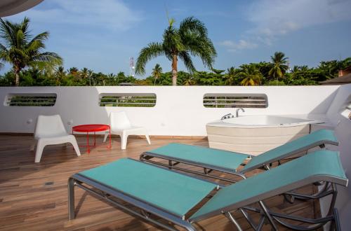 a balcony with a tub and a table and chairs at Puerto Plaza Las Terrenas in Las Terrenas