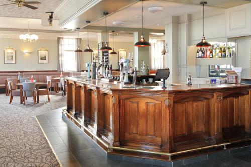a large wooden bar in a restaurant with tables at The Marine Hotel in Hartlepool